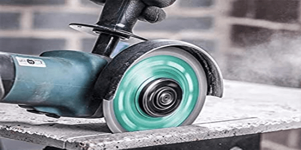 miniamoladora con disco de diamante cortando baldosa